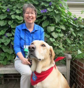 Woman and dog in garden.