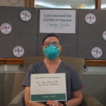Barclay Friends Employee with vaccine sign